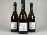 trois bouteilles de vin posées l'une à côté de l'autre sur une table