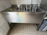 un évier dans un coin de la cuisine, avec une poubelle à l'intérieur