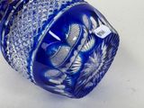 a blue glass vase with a flower design on it