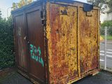 a rusted out dumpster sitting on the side of the road
