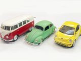 three toy cars sitting next to each other on a white surface