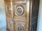 une armoire en bois avec une porte et un tapis posé au sol