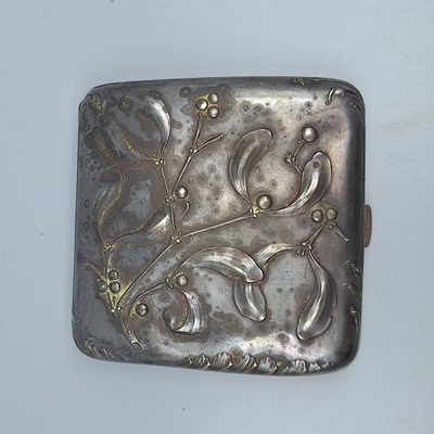 une boîte argentée ornée d'un motif sur un fond blanc