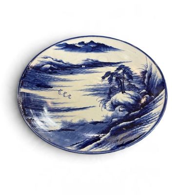 a blue and white plate with a picture of a man riding a horse