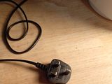 a plug that is plugged into the wall next to a lamp