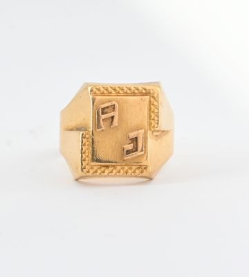 un gros plan d'une bague en or ornée d'un motif carré