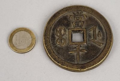 une petite pièce à côté d'une pièce encore plus petite, posées sur une surface blanche