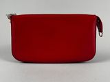 a red purse sitting on top of a white surface
