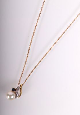 un collier en or orné d'un pendentif composé d'une perle et d'un diamant