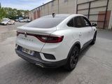 the rear end of a white car parked in a parking lot