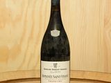 une bouteille de vin posée sur un tonneau en bois