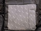 a black leather chair with a gray blanket on it