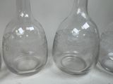 three clear glass bottles sitting on top of a white table