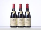 three bottles of wine are lined up on a table
