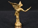 une figurine en or représentant un ange sur fond noir