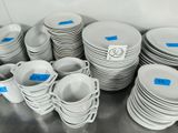a lot of white plates and cups on the table