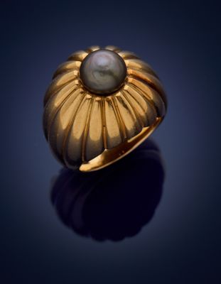 a gold ring with a pearl in the center