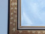 a picture of a mirror on the wall with a sky in the background