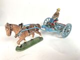 deux figurines représentant des chevaux tirant une calèche dans laquelle se trouve un homme