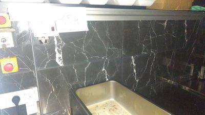 a sink in the middle of a kitchen with a black marble counter top