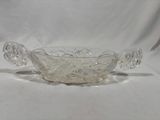 a clear glass bowl with a handle and two handles