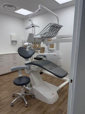 an image of a dentist ' s office with a chair and dental equipment