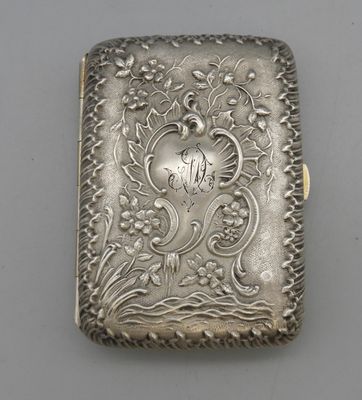 un étui à cigarettes ancien en argent, orné d'un motif représentant un oiseau et des fleurs
