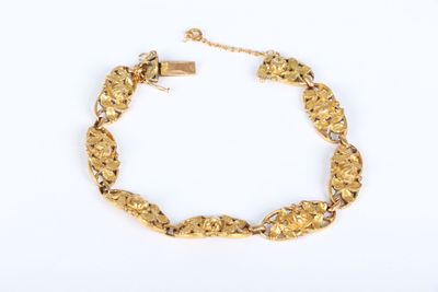 a close up of a gold bracelet on a white background