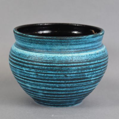 a blue and black vase sitting on a table