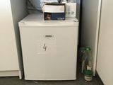 a small refrigerator in the corner of a kitchen