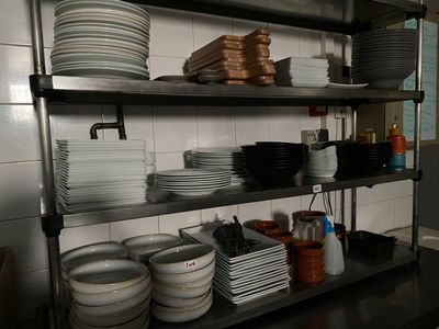 beaucoup d'assiettes et de bols sur les étagères de la cuisine