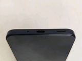 the back of a black cell phone sitting on top of a white table