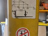 a yellow pole with some signs on it in a garage