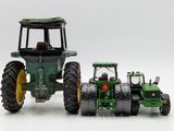 a toy tractor and a toy tractor on a white surface