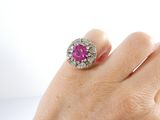 a woman ' s hand with a pink and white ring on it
