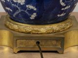 a blue bowl with white flowers on it on a gold stand