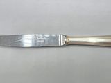 an old silverware knife with a long handle on a table