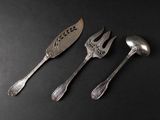 three forks and spoons sitting next to each other on a black surface