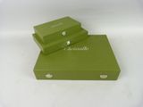 two green boxes are stacked on top of each other on a white surface