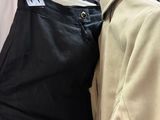 two men ' s jackets hanging on a rack in a clothing store