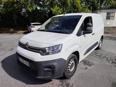 la camionnette blanche est garée sur le parking à côté des arbres