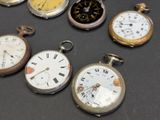 many different types of pocket watches on the table