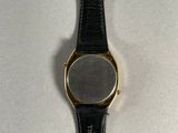 a close up of a watch on a white surface with a black strap
