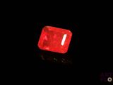 a close up of a red diamond on a black surface