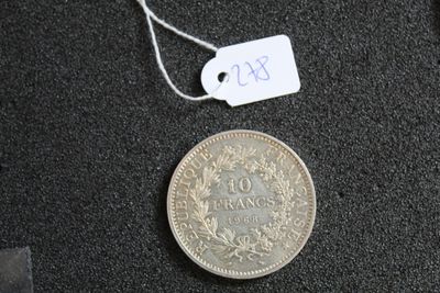 une pièce de monnaie sur laquelle est accrochée une étiquette de prix, à côté d'un bout de papier