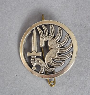 une image représentant un pendentif en or et en argent orné d'un oiseau