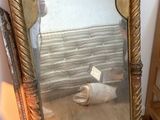 a large mirror sitting on a wooden floor next to a bed
