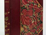 an old book with a red cover and gold decorations on it