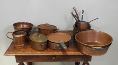 de nombreuses casseroles et poêles posées sur une table en bois