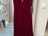 a red dress hanging on a hanger in front of a mirror